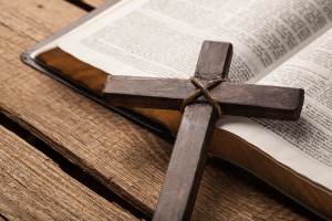 Holzkreuz liegt auf einer Bibel